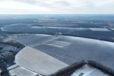 View from a height of a large winter landscape with a snowy field and forests Foto stock