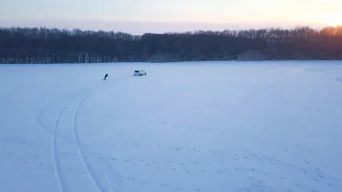 View from height to man is riding a snowboard on a snow-covered field on a cable Stock Footage 85131728