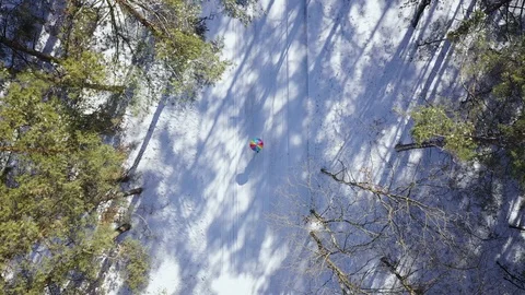 View from the height on a person under a rainbow umbrella walking in the winter Stock Footage 103943612
