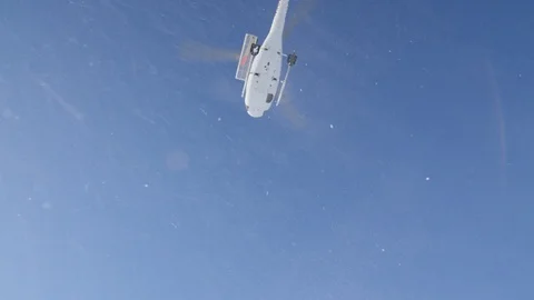 Up view of Helicopter flying away against blue sky in slow motion, Alaska Stock Footage 129121769