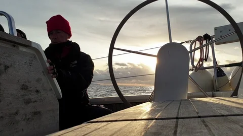 View of the helm wheel with the background of a winter sunset with the skipper Stock Footage 120745187