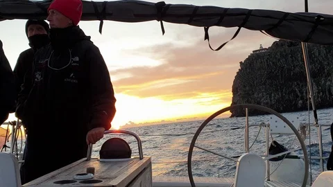 View of the helm wheel with the background of a winter sunset with the skippers Stock Footage 120745549