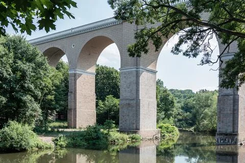 View of the high bridge over the river against the background of the forest. Stock Photos