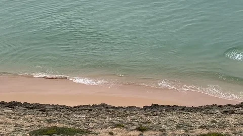 View from high on a cliff to remote beach below Stock Footage 107608135
