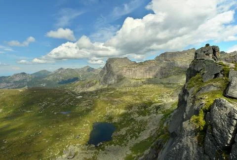 A view from a high cliff to a valley with small lakes circled by high mount.. Stock Photos