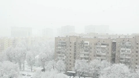 The view from a high floor at the winter town with falling snow. Stock Footage 115448579