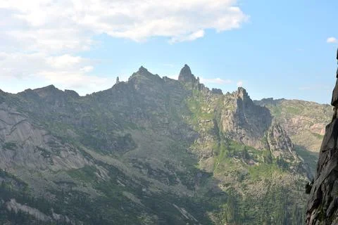 View of a high mountain range with peaked peaks on a summer sunny day. Foto stock