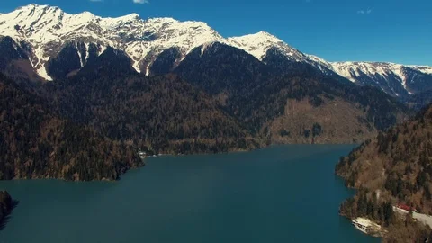 A view of the high mountains with snow tops, at the foot of the lake and Stock Footage 89896325