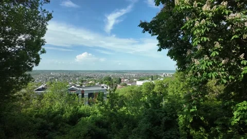 View from a high point shows cityscape under a clear sky with scattered clouds Stock Footage 335589295