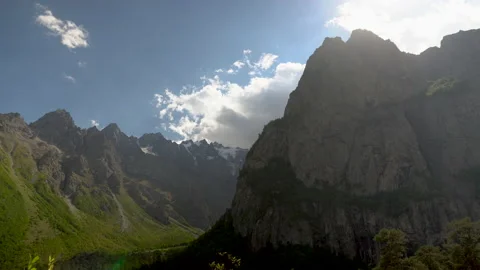 View of high rocky mountains with clouds in the sky. Timelapse. Stock Footage 140275981