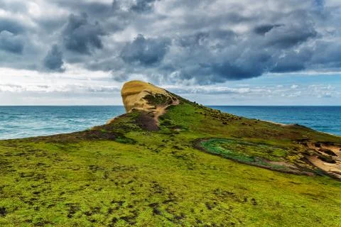 View of high sandy cliff covered with grass and waves of Pacific ocean at Tun Stock Photos