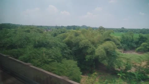 View from High Speed Train Window Passing Urban and Rural Landscape in Indonesia Stock Footage 332054254