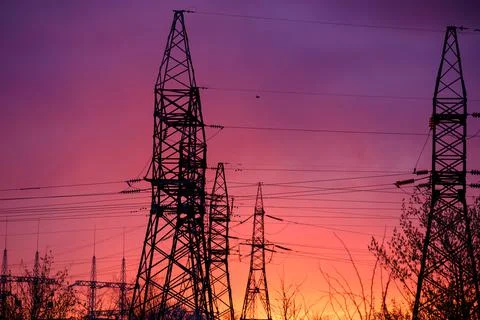 View of high voltage pole power transmission tower on sunset. Panorama high Stock Photos