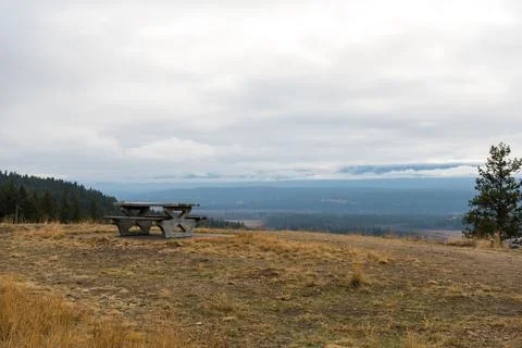 View from a hillside with a picnic table on a cloudy day in the countryside Stock Photos