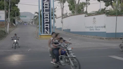 View of hispanic people  on motorcycle in small guatemalan village Stock Footage 233478131