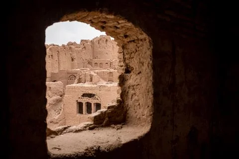 View from a hole in the wall on the ancient city ruins in the desert in iran Stock Photos