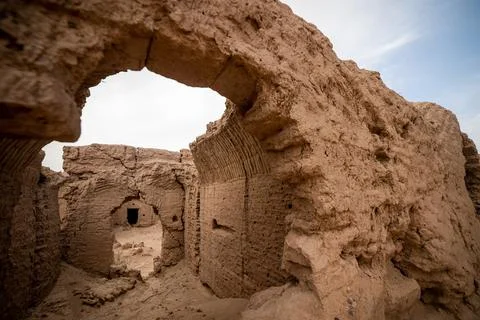 View from a hole in the wall on the ancient house ruins in the desert in iran Stock Photos