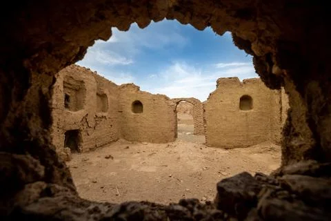 View from a hole in the wall on the ancient house ruins in the desert in iran Stock Photos