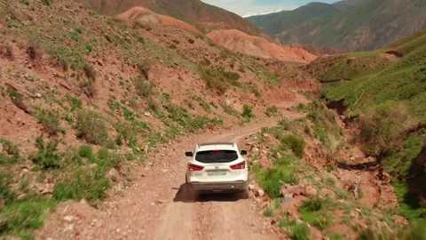 A view of the hood of a white SUV moving along a dry, dusty road Stock-Footage 276645693