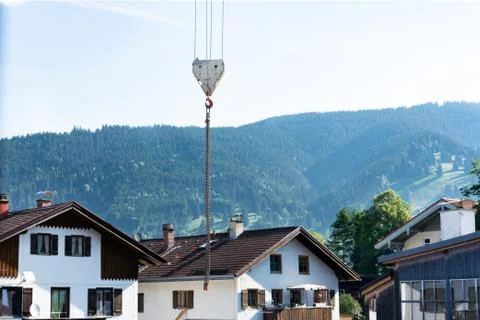 View of the hook from the crane with a chain against the background of houses Stock Photos