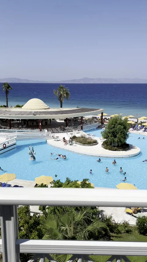 A view of the hotel grounds with the ocean, pool and sunbathing tourists. Stock Footage 236925654