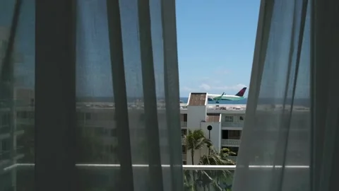 View from hotel window of low-flying airplane that lands in Sint Maarten airport Stock Footage 233233812