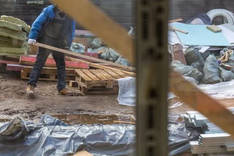 View from house through window on the worker in protective gloves who is working Stock Photos