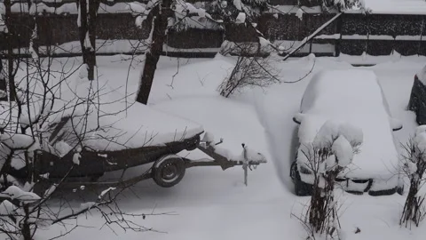 View from a house window overlooking a snow-covered countryside yard with trees. Stock Footage 326093234