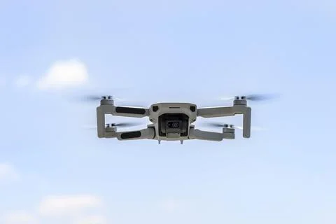 View of the hovering drone from front against a blue sky background, the plas Stock Photos