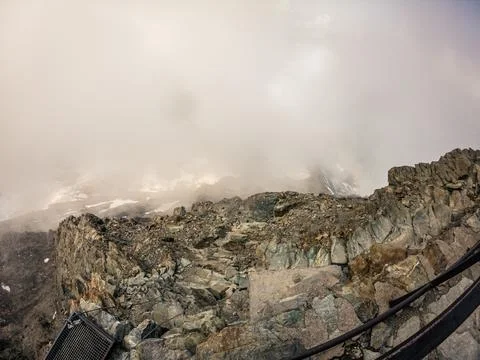 View of huge rock steps path to Mont Blanc with steel rope in foggy day, mi.. Stock Photos