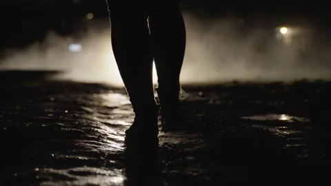 View of human legs walking towards the light on a dark night through the fog. Stock Footage 233717402