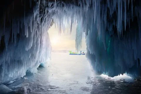 View from the ice cave with huge icicles on the frozen Lake Baikal at sunset. Stock-Fotos
