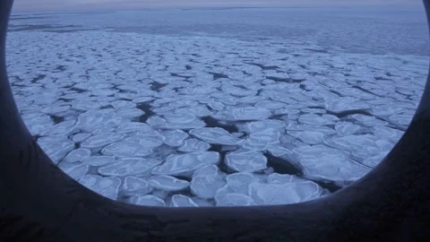View of ice through bow clew. Pancake ice floes float by Stock Footage 229855741