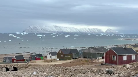 View of icebergs and mountains in the distance at a coastal village in Greenland Stock Footage 339999749