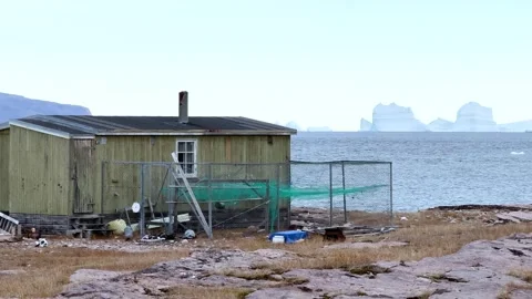 View of icebergs and mountains in the distance at a coastal village in Greenland Stock Footage 339999787