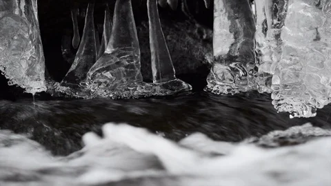 View of icicles in small creek as water flows Stock Footage 85899305