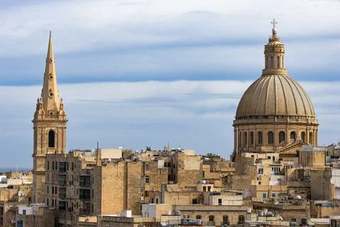 View of the iconic dome and spire over the historic cityscape of Valletta Stock Photos