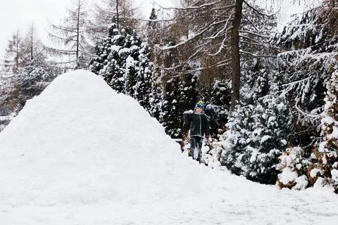 View of an igloo in a winter landscape and boy playing Stock Photos