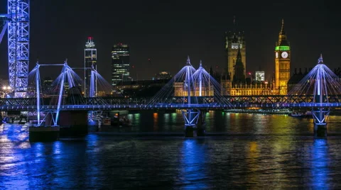 View of illuminated Tower Bridge and Palace of Westminster in London Stock Footage 65873154