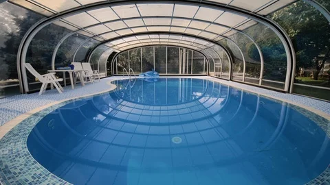 View of indoor pool with bright blue water on side lies an inflatable dolphin Stock Footage 120837950