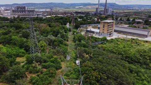 View of industrial area with power lines and buildings on a sunny day Stock Footage 339649284