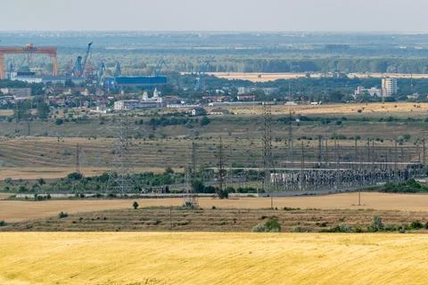 View of industrial area with power lines and fields near a city during daytim Stock Photos