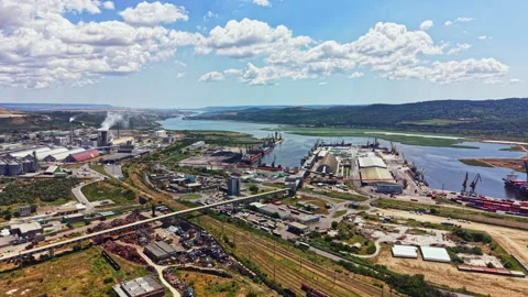 View of an industrial area by a river with cargo ships, factories, and a highway Vídeo Stock 341569795