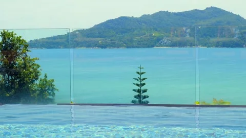 View from infinity swimming pool on blue bay with turquoise water Stock Footage 242737889