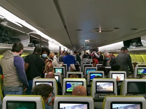 View from inside an airplane after the flight, with people taking hand luggage Stock Photos