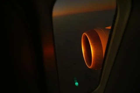 View from inside airplane to outside wing engine during dawn. Sun ray reflect Stock Photos