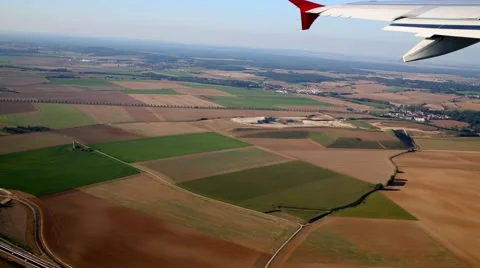 View from inside airplane through porthole at wing and earth. Stock Footage 57443708
