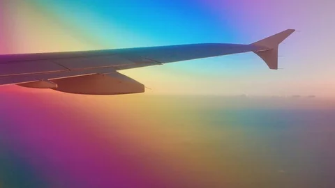 View from inside of airplane window looking at airplane wing and clouds Vidéo 103432120