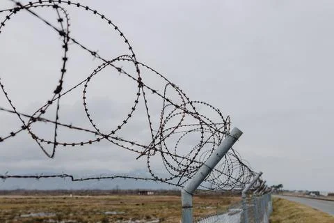 View inside and along the round barbed wire along the road Stock Photos