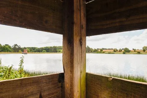 View from inside a bird hide for birdwatching with view out over water Stock Photos